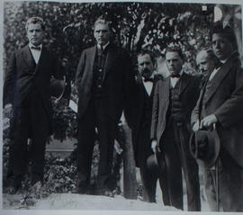 Manuel M. Ponce posando con un grupo de hombres en un jardín.