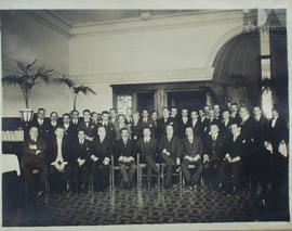 Manuel M. Ponce posando con un grupo de caballeros en un salón.
